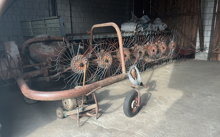 Stara maszyna rolnicza w magazynie, pokryta rdzą.