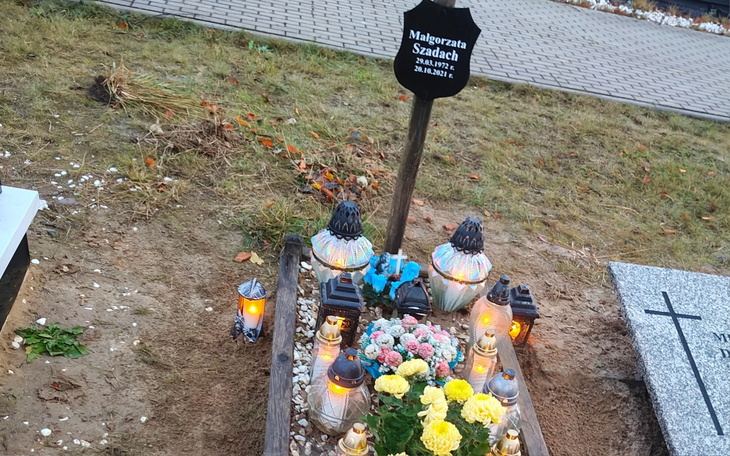 Grób z lampionami i kwiatami, upamiętniający zmarłego.