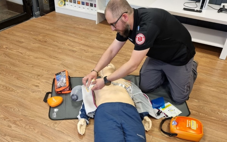 Mężczyzna wykonujący resuscytację na manekinie.