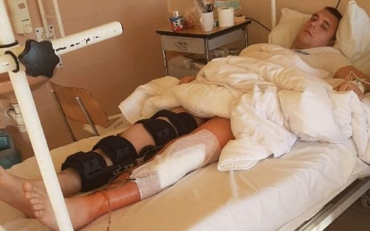 Mężczyzna leży w szpitalnym łóżku, otulony kocem.