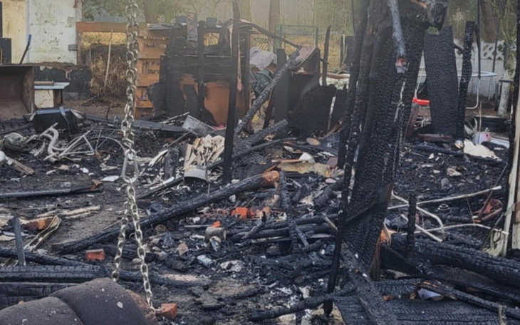 Zniszczony teren po pożarze, pełen popiołów i gruzów.