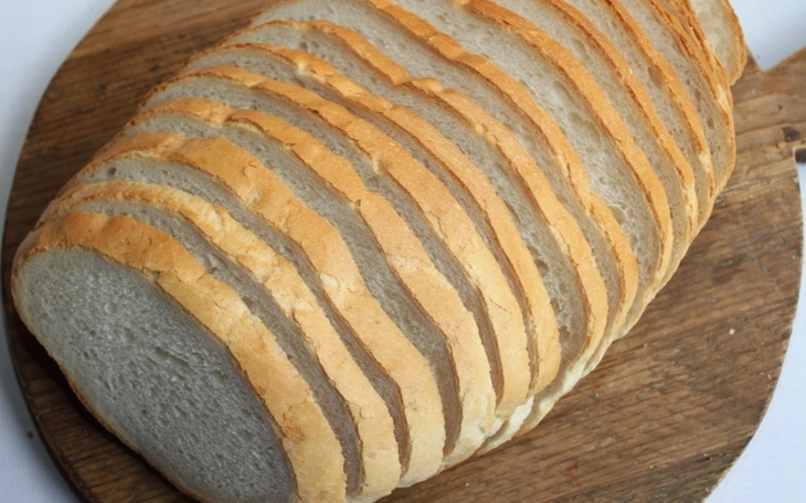 Pokrojony chleb na desce, świeżo upieczony.