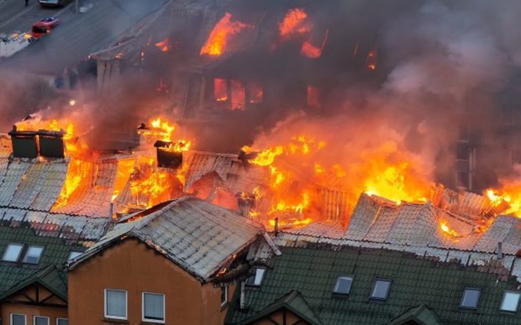 Pożar budynku, ogień trawi dach i ściany.