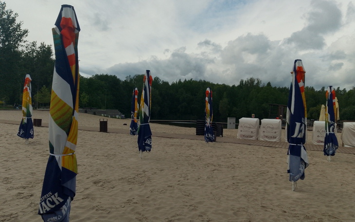 Plaża z parasolami, spokojna atmosfera przed burzą.