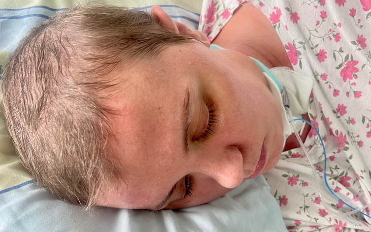 Kobieta leżąca w łóżku, z zamkniętymi oczami.