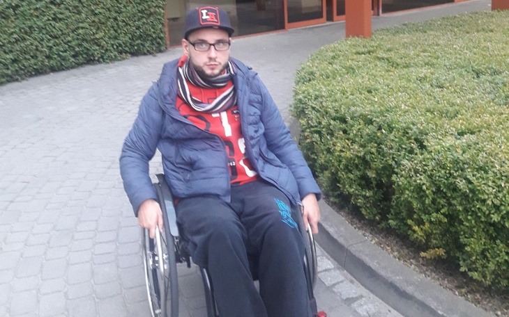 Mężczyzna na wózku inwalidzkim, spędzający czas na świeżym powietrzu.