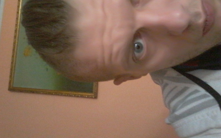 Mężczyzna z nietypową fryzurą, patrzący w stronę kamery.