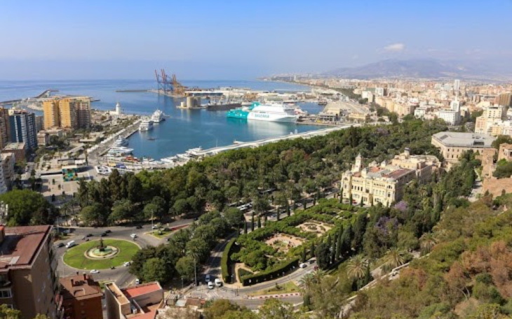 Widok na port w Maladze, z zielonymi terenami wokół.