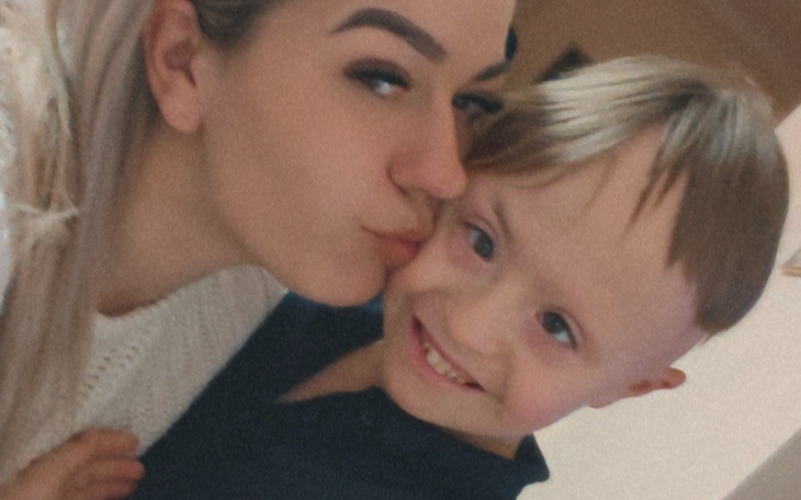 Osoba całująca dziecko w policzek.