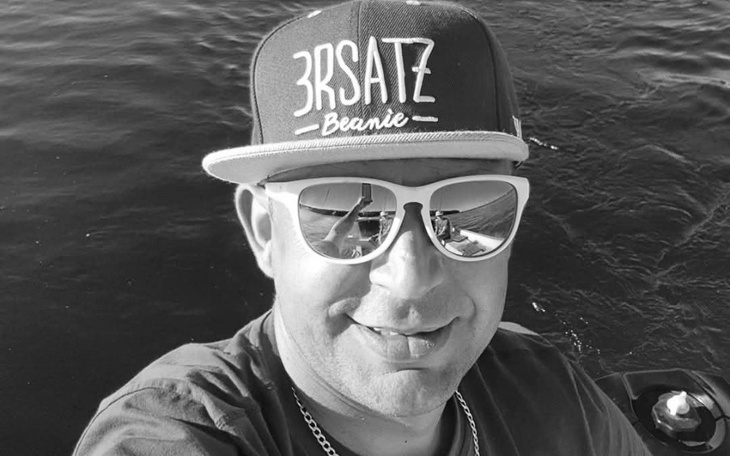 Mężczyzna w czapce i okularach przeciwsłonecznych na łodzi.