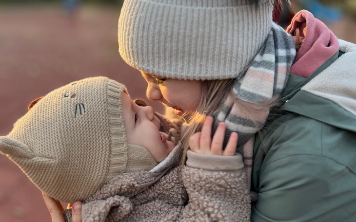 Dziecko w ciepłym ubraniu, przytulające się do drugiego dziecka.