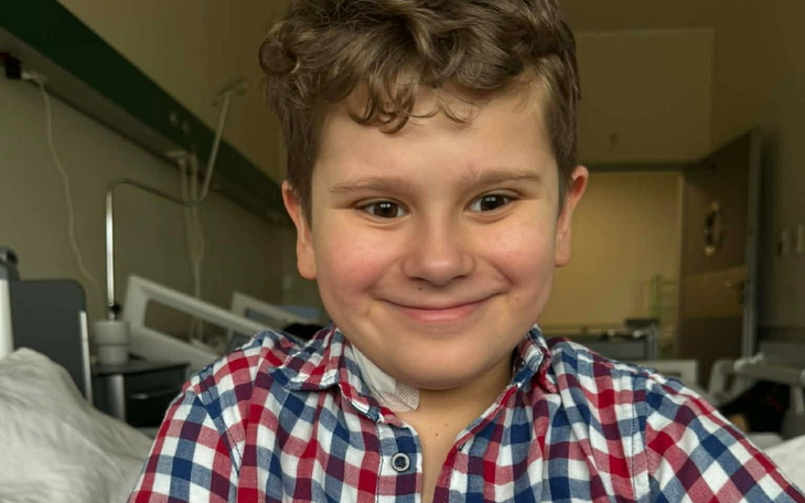 Chłopiec uśmiechający się w szpitalnym łóżku.