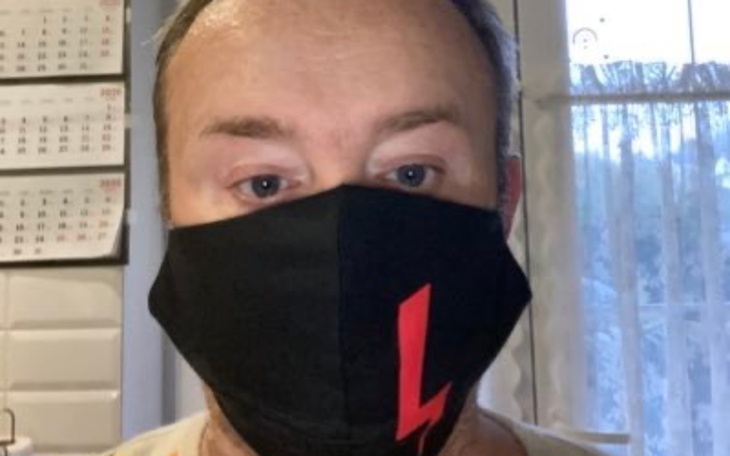 Mężczyzna w czarnej masce na twarzy.