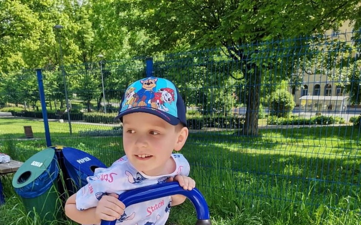 Chłopiec bawiący się na placu zabaw w parku.