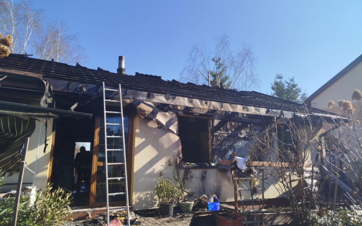 Zniszczony dom po pożarze, widoczne uszkodzenia dachu.