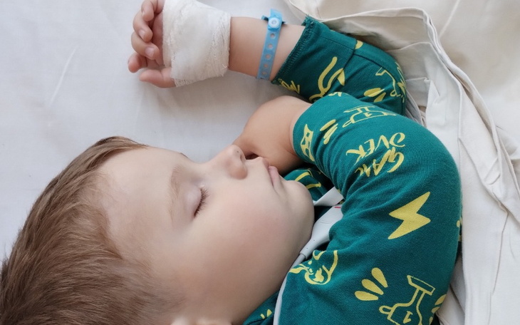 Chłopiec śpiący w szpitalnym łóżku.