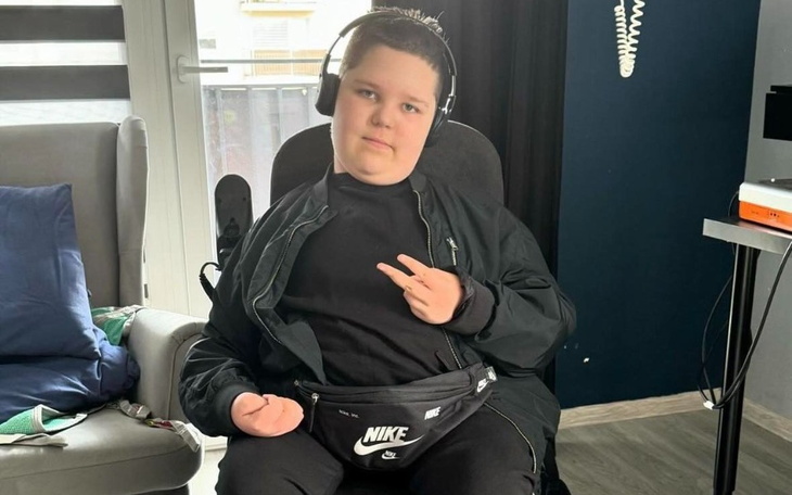 Chłopiec w słuchawkach, pozujący z gestem pokoju.