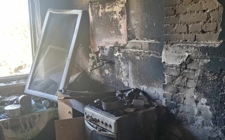 Zniszczona kuchnia po pożarze, z uszkodzonymi sprzętami.