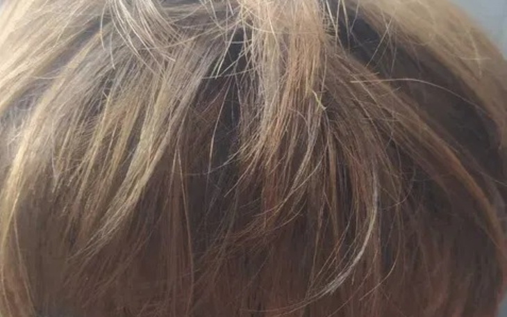 Zbliżenie na fryzurę, jasne pasma włosów w naturalnym świetle.