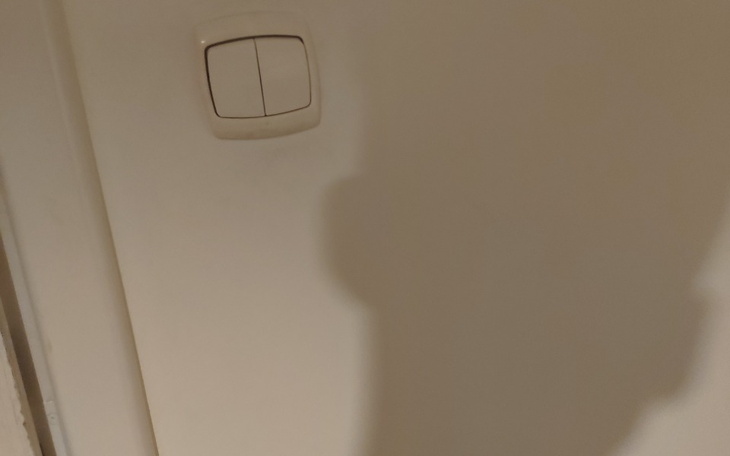 Cień na ścianie obok włącznika światła.