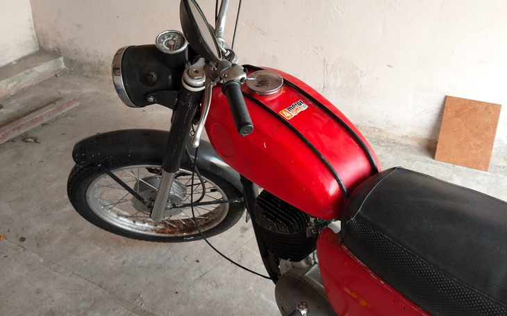 Czerwony motocykl stoi w garażu, czeka na jazdę.