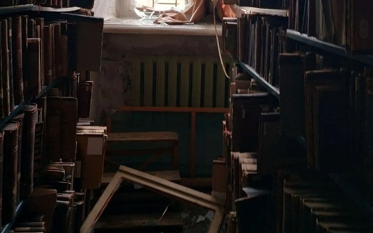 Zniszczona biblioteka z książkami i oknem wpuszczającym światło.