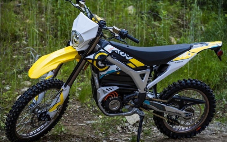 Nowoczesny motocykl terenowy na tle zieleni.