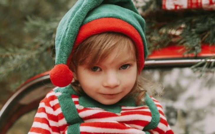 Mały chłopiec w elfickim stroju, uśmiechający się do kamery.