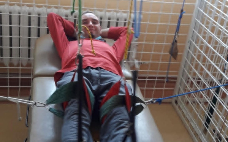 Mężczyzna relaksujący się na leżance w rehabilitacji.