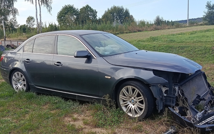 Uszkodzony samochód zaparkowany na trawie.