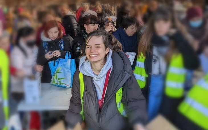 Uśmiechnięta wolontariuszka w tłumie ludzi podczas akcji.