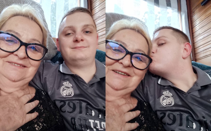 Mężczyzna całuje kobietę w okularach, oboje uśmiechnięci.