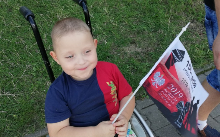 Chłopiec z flagą, radosne chwile na świeżym powietrzu.