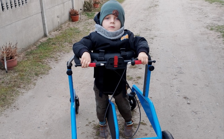 Małe dziecko na wózku spacerowym na drodze.