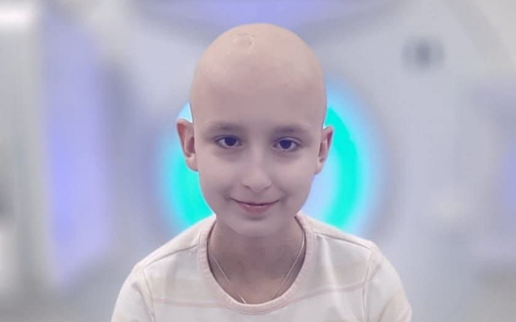 Młoda dziewczynka uśmiechająca się w szpitalu, walcząca z chorobą.