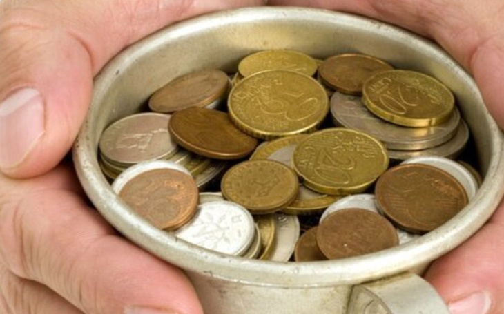 Ręce trzymające kubek pełen monet, symbolizujące wsparcie.