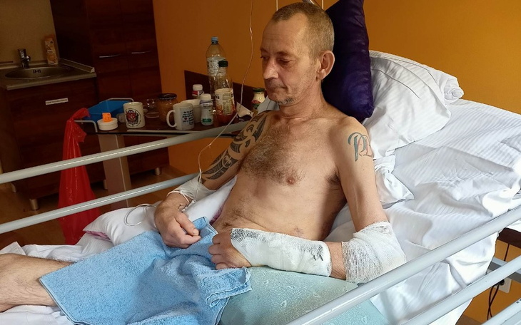 Mężczyzna w szpitalu, z opatrunkami na rękach.