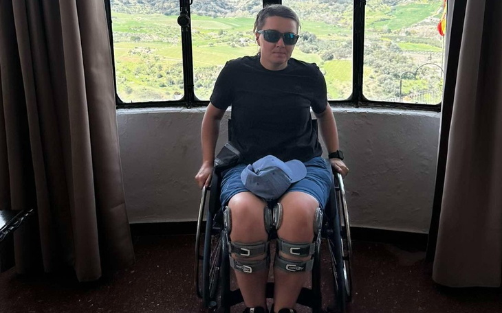Kobieta na wózku inwalidzkim w malowniczym otoczeniu.