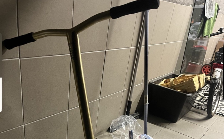 Hulajnoga w garażu, obok różnych przedmiotów.