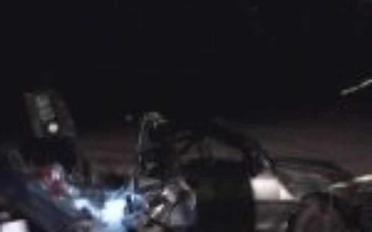 Uszkodzony samochód w ciemności, z widocznymi elementami mechanicznymi.