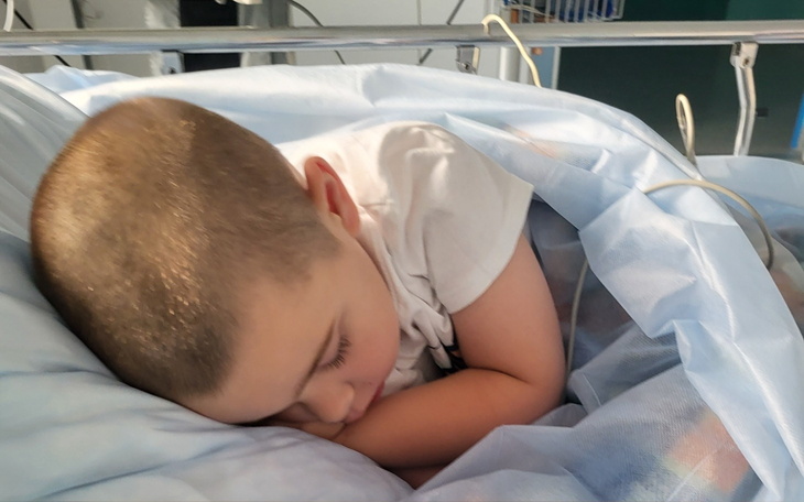 Mały chłopiec śpiący w szpitalnym łóżku.