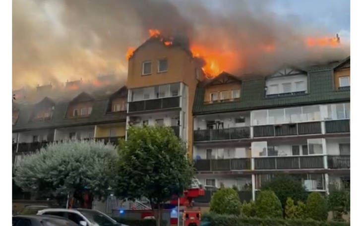 Pożar na dachu budynku, strażacy w akcji.