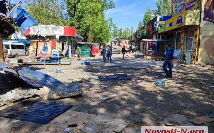 Zniszczona ulica z ludźmi sprzątającymi po katastrofie.