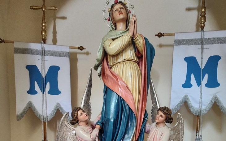 Figurka Matki Boskiej z aniołkami w tle.