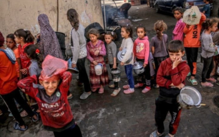 Dzieci w kolejce na ulicy, niektóre z brudnymi twarzami.