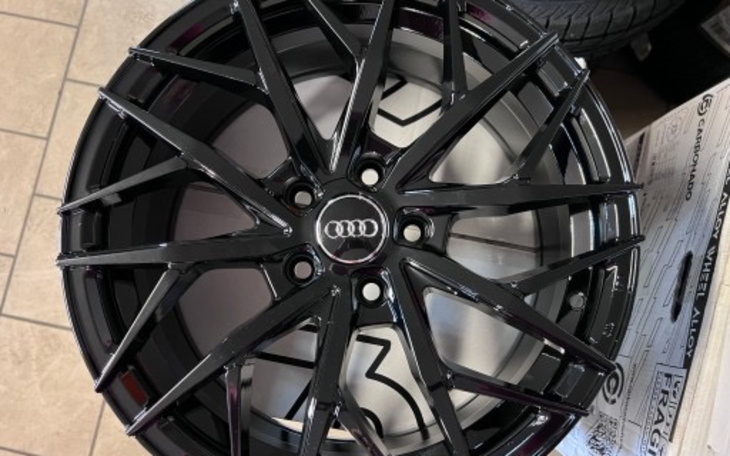 Czarna felga samochodowa z logo Audi.