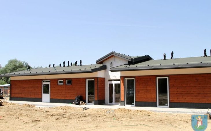 Nowoczesny budynek z drewnianą elewacją w otoczeniu natury.