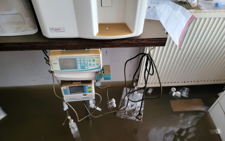 Zalane pomieszczenie z urządzeniami medycznymi na podłodze.