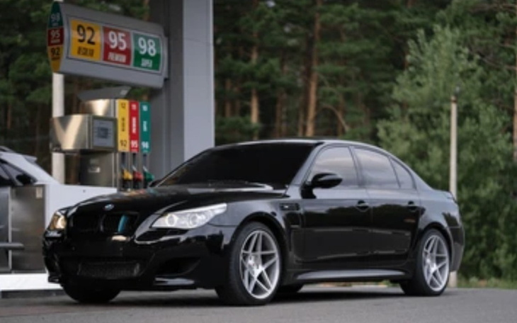 Czarny samochód zaparkowany na stacji benzynowej w lesie.