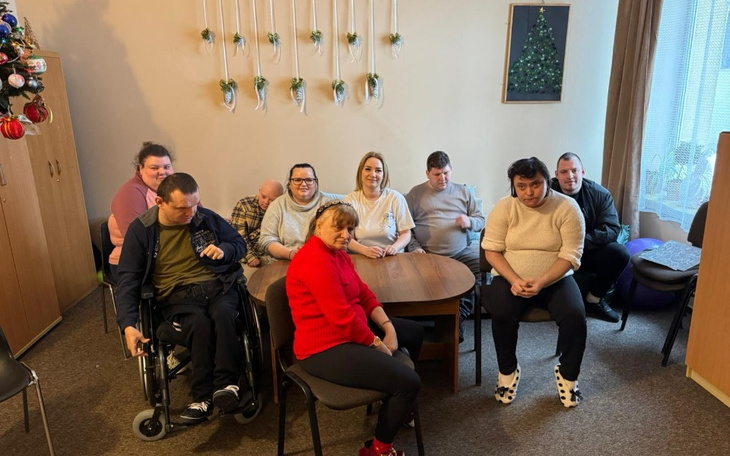 Grupa osób w przytulnym pomieszczeniu, spędzających czas razem.